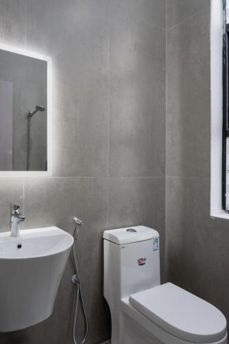 a bathroom with a white toilet and a sink at Taibah Guide Apartments in Medina
