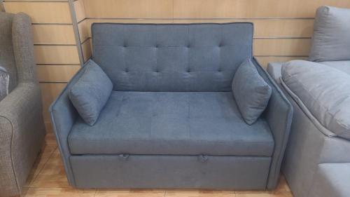 a blue couch in the corner of a room at Edificio La Biznaga PQ in Málaga
