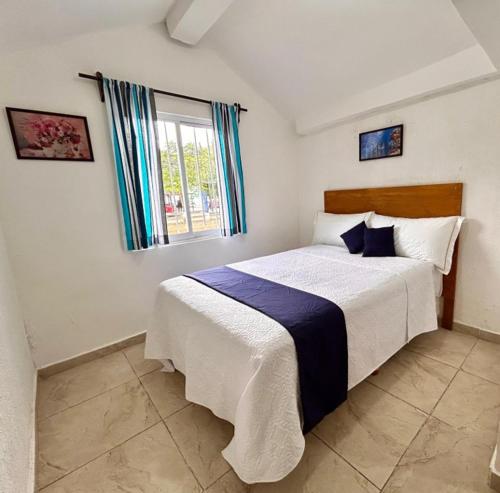 een slaapkamer met een bed en een raam bij Íkaro Suites Cancún in Cancun