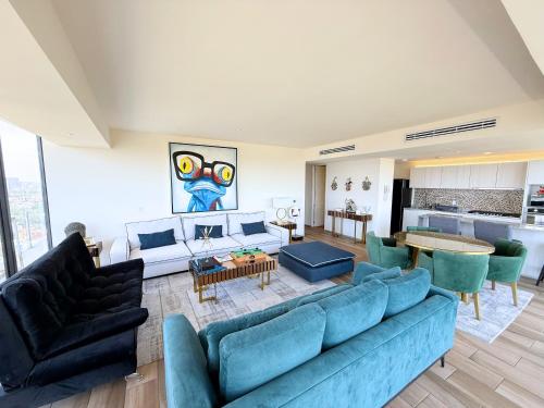 a living room with a blue couch and chairs at Departamento Grand 4H-154 in Guadalajara