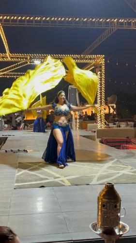 a woman sitting on a stage with a performance at Sunset Luxury camps in Dubai