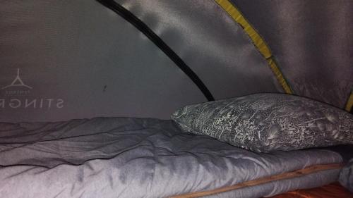 a bed in a tent with a pillow on it at Tentes suspendues D'En Haut in Friaudour