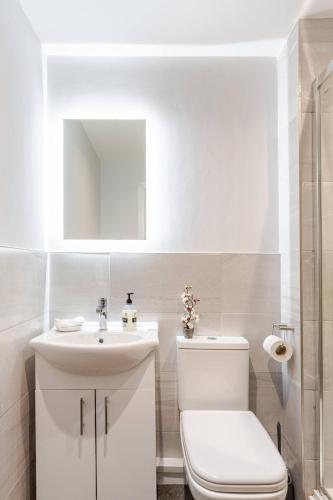 a white bathroom with a toilet and a sink at Luxury 1-Bedroom City Centre Apartment, Liverpool Hideaway in Liverpool