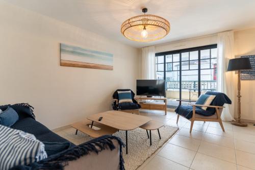 a living room with a couch and a table at Proche mer très agréable appt de 2 ch pour 5 pers garage en ss in Le Touquet-Paris-Plage