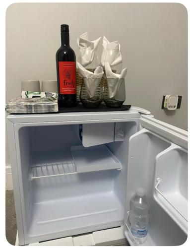 a bottle of wine sitting on top of an open refrigerator at Sammy's guest house in Prescot