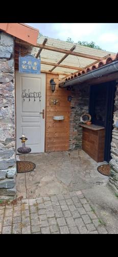 un garage avec une porte blanche et un bâtiment dans l'établissement La maisonette Mellona, à Chanzeaux