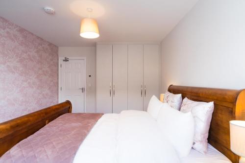 a bedroom with a large bed with white pillows at Dublin Premier Homestay in Ráth Cúil