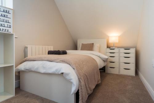 a small bedroom with a bed and a dresser at Dublin Premier Homestay in Ráth Cúil