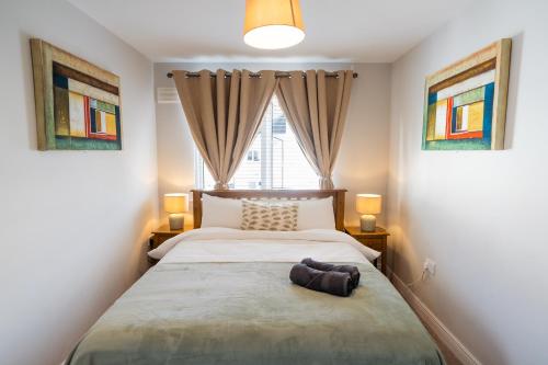 a bedroom with a large bed with two windows at Dublin Premier Homestay in Ráth Cúil