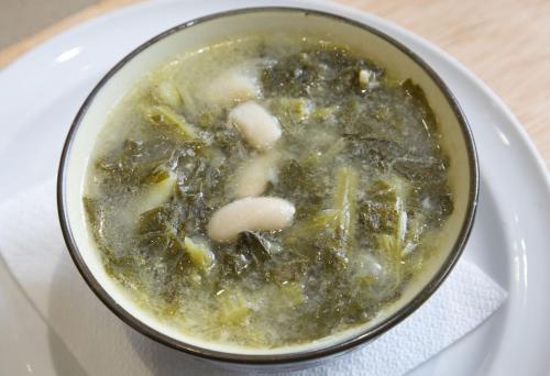 a bowl of soup on a plate on a table at Hotel Carlos 96 in Melide