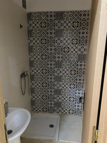 une salle de bain avec une douche avec des toilettes et un lavabo dans l'établissement Appartement à Skhirat, à Skhirat