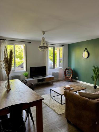 a living room with a couch and a table at Maison Cosy au pied des vignes in Lussac