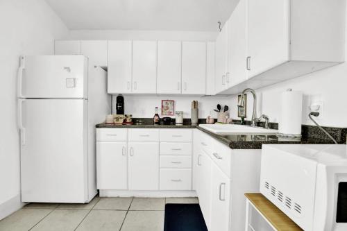 cocina blanca con armarios blancos y nevera en Luxe Pool Casita w Saltwater Pool 25 Min to PCB, en Panama City