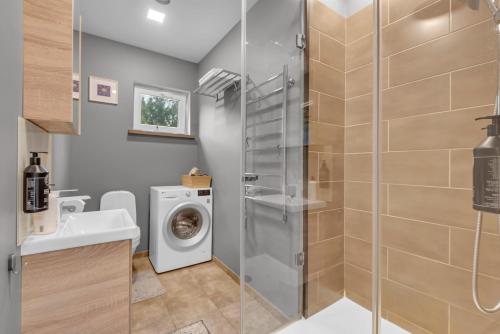 a bathroom with a washing machine and a sink at The Flower Nest in Zvejniekciems