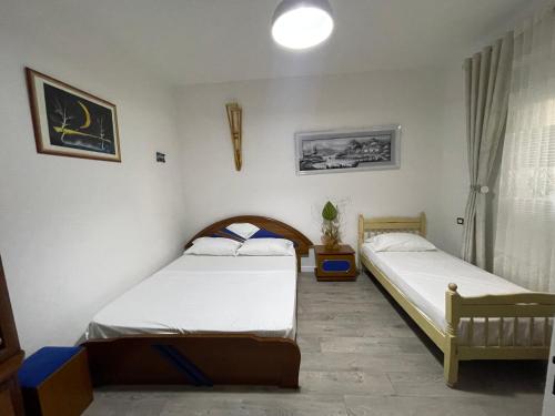 a bedroom with two beds and a window at Klarisa Beach Apartment in Golem