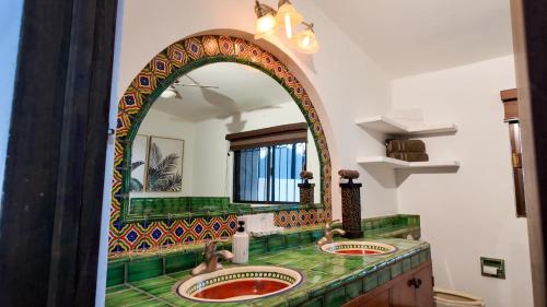 a bathroom with two sinks and a large mirror at White House Cabo in Cabo San Lucas