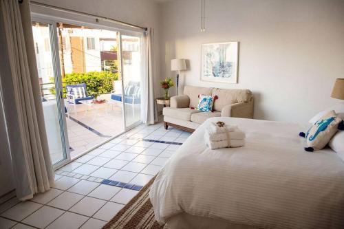 a bedroom with a bed and a living room at 2BR Steps to Malecón Panoramic views Private pool in La Paz