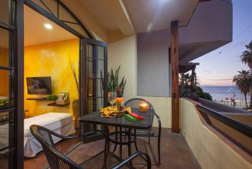 a room with a table and chairs on a balcony at 20 ft to malecón, downtown, private Pool in La Paz