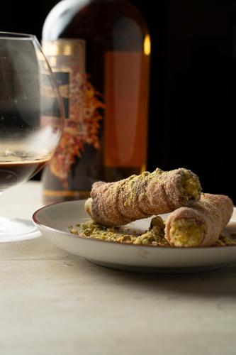 a plate of food on a table with a glass of wine at Novotel São Paulo Berrini in Sao Paulo