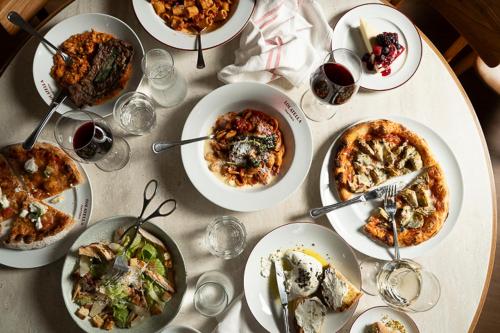 a table topped with plates of food and glasses of wine at Novotel São Paulo Berrini in Sao Paulo