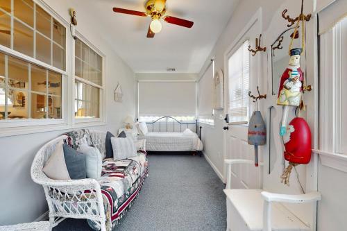 ein Wohnzimmer mit einer Couch und einem Deckenventilator in der Unterkunft Hen Cove Cottage in Pocasset