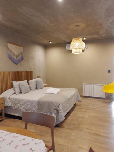 a bedroom with two beds and a chandelier at Sol Suites in Villa Cura Brochero