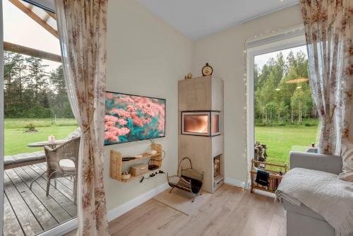 a bedroom with a fireplace and a large window at The Flower Nest in Zvejniekciems