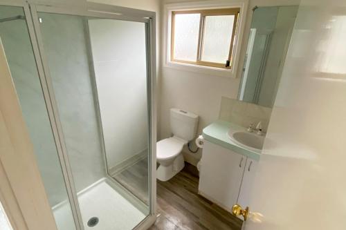 a bathroom with a shower and a toilet and a sink at BIG4 Breeze Holiday Parks - Busselton in Busselton