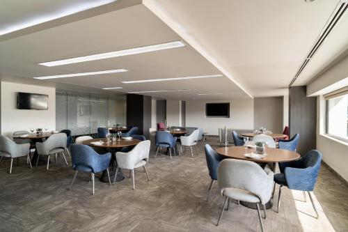a restaurant with tables and chairs in a room at Real Inn Tijuana by Camino Real Hoteles in Tijuana