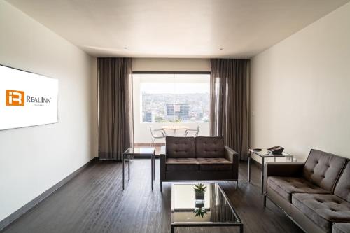 a living room with two couches and a table at Real Inn Tijuana by Camino Real Hoteles in Tijuana