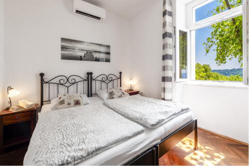 a bedroom with a bed and a large window at Apartments Kirigin in Dubrovnik