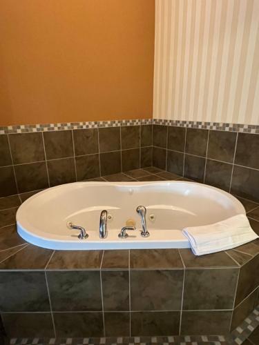 a bath tub with two faucets in a bathroom at Prestige Prince George Lodge in Prince George