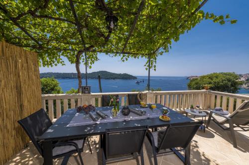 a table on a deck with a view of the water at Apartments Kirigin in Dubrovnik