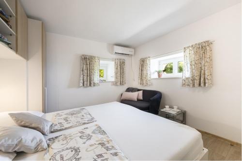 a bedroom with a bed and a chair in it at Apartments Kirigin in Dubrovnik