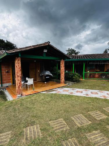 a house with a deck with a table and an umbrella at Magical farmhouse near Arví Park in Mazo