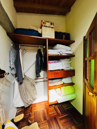 a room with a closet with shelves and towels at Magical farmhouse near Arví Park in Mazo