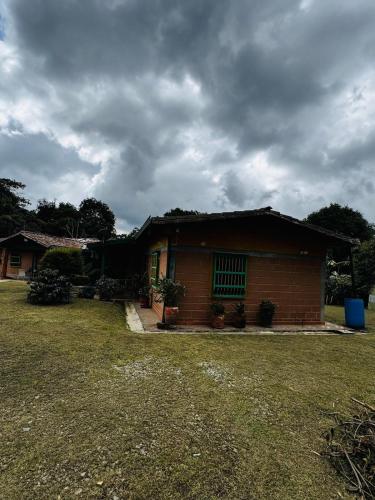 a small house with a grass yard in front of it at Magical farmhouse near Arví Park in Mazo