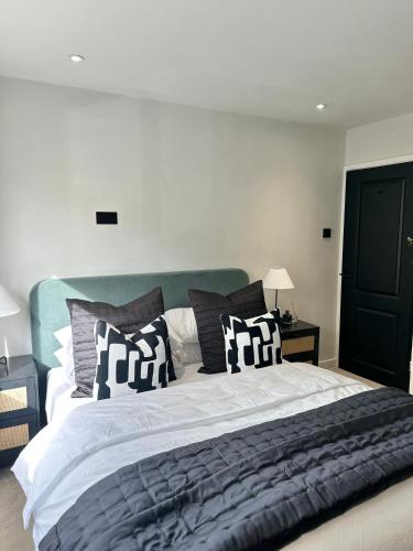 a bedroom with a large bed with black and white pillows at Convenient City House By Ankers Contractors Accommodation Manchester With Free Parking in Manchester