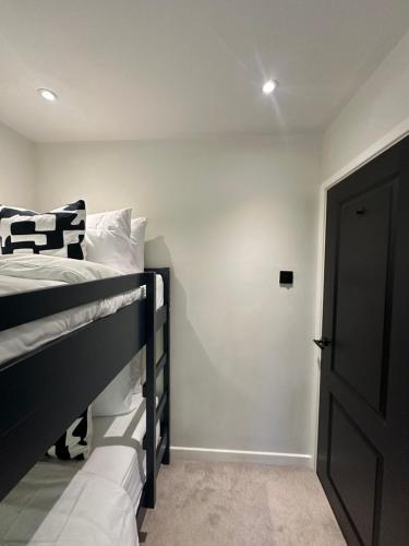 a bedroom with a black bunk bed and a door at Convenient City House By Ankers Contractors Accommodation Manchester With Free Parking in Manchester