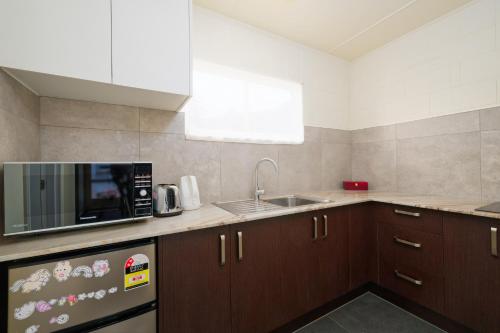 a kitchen with a sink and a microwave at Blue Seas Motel in Kaikoura