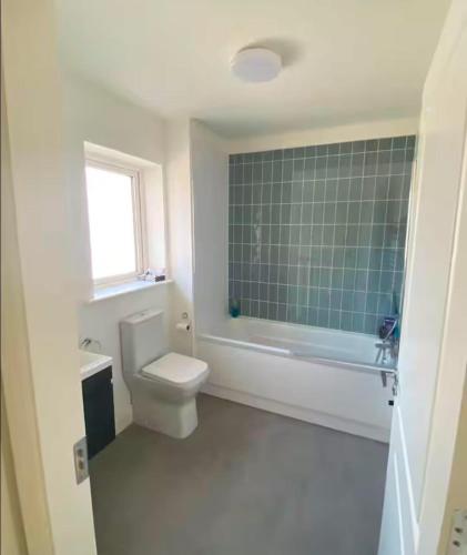 a bathroom with a toilet and a green tile wall at Luxury House Newbridge Kildare - 3 double bedrooms - sleeps 6 - 25 minute train Dublin City Centre in Newbridge