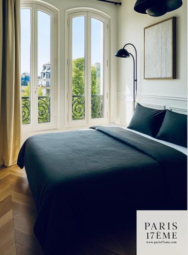 - une chambre avec un grand lit en face des fenêtres dans l'établissement Paris 17 Elegance and Light Monceau and Batignolles, à Paris