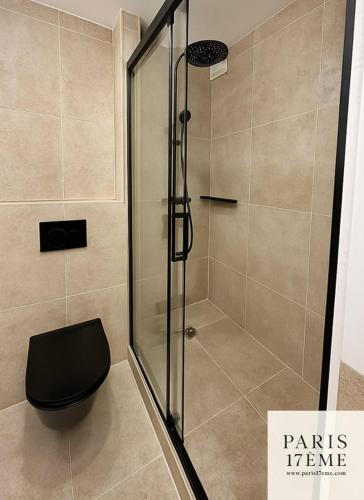 La salle de bains est pourvue d'une douche et de toilettes noires. dans l'établissement Paris 17 Elegance and Light Monceau and Batignolles, à Paris
