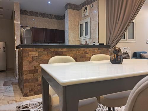 a kitchen and dining room with a table and chairs at Al Fayrouz Palace Apartments in Luxor