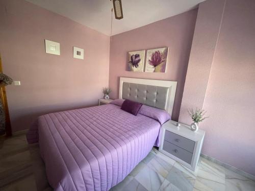 ein lila Schlafzimmer mit einem Bett mit einer lila Bettdecke in der Unterkunft Vista Hermosa Costa Granada in Castell de Ferro