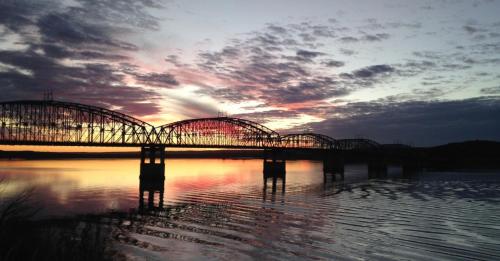 a bridge over a body of water with a sunset at A Bridge View Inn in Chamberlain