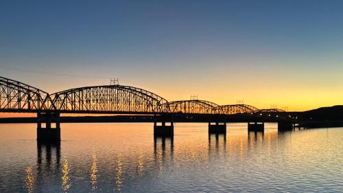 a bridge over the water with the sunset in the background at A Bridge View Inn in Chamberlain