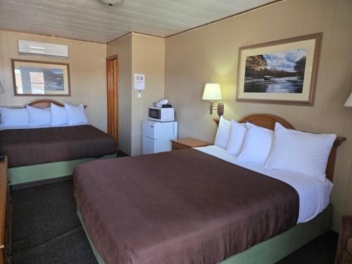 a hotel room with two beds and a microwave at A Bridge View Inn in Chamberlain