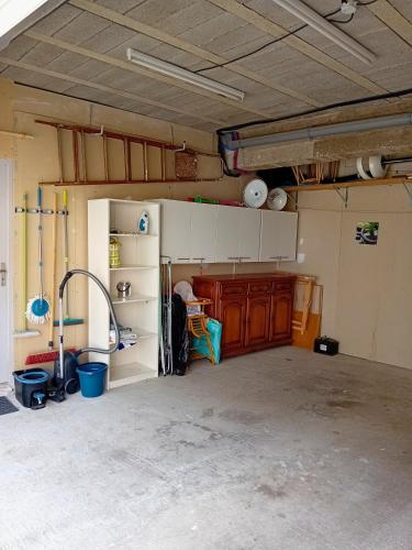 a garage with a room with a kitchen with a refrigerator at Maison cosy à Pérols - proche plage & Parc Expo Arena - clim, garage in Pérols