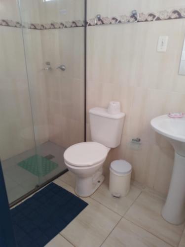 a bathroom with a toilet and a shower and a sink at Pousada Desfiladeiro da Serra in Serra Negra